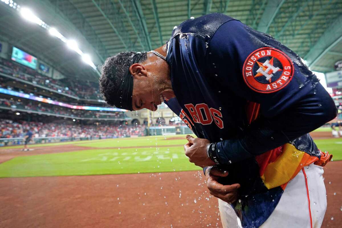Houston Astros' Jeremy Pena bend down after being doused with water by teammates after hitting a game-winning two-run home run against the Toronto Blue Jays in the 10th inning of a baseball game Sunday, April 24, 2022, in Houston. The Astros won 8-7 in 10 innings. (AP Photo/David J. Phillip)