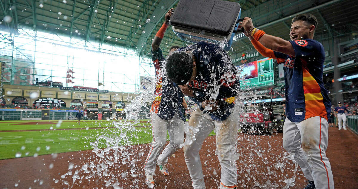 Houston Astros' Jeremy Pena, center, is doused with water by Houston Astros' Aledmys Diaz, right, and Martin Maldonado, left, after hitting a game-winning two-run home run against the Toronto Blue Jays in the 10th inning of a baseball game Sunday, April 24, 2022, in Houston. The Astros won 8-7 in 10 innings. (AP Photo/David J. Phillip)