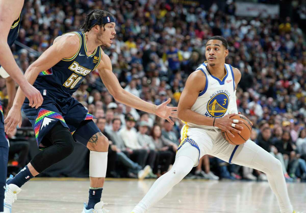 Golden State Warriors guard Jordan Poole, right, stops in the lane as Denver Nuggets forward Aaron Gordon defends in the first half of Game 4 of an NBA basketball first-round Western Conference playoff series, Sunday, April 24, 2022, in Denver. (AP Photo/David Zalubowski)