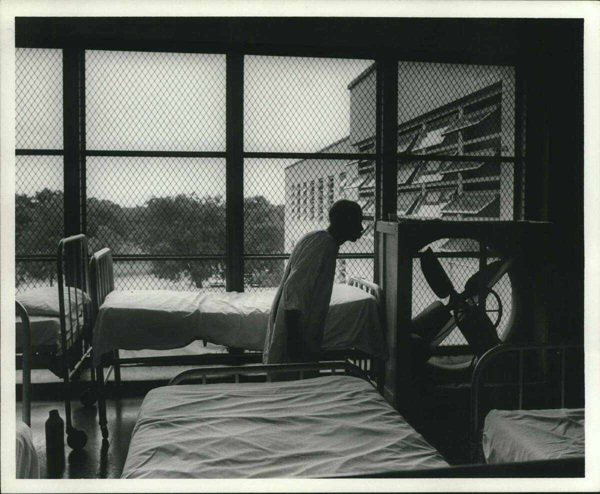 A male patient at Terrell State Hospital walked past a porch crowded with patient beds in 1967. In the 1950s, news of deplorable conditions at state hospitals across the country — coupled with the advent of medications such as thorazine — brought on a new wave of mental health treatment that focused on community-based care rather than hospitalization. But community mental health centers never received adequate funding, even as the number of hospital beds shrunk rapidly.