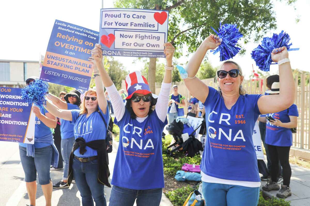 Nurses Dolores Nino (center) and Ami Wells (right) participate on opening day of a nurses’ strike outside of Lucile Packard Children’s Hospital in Palo Alto.