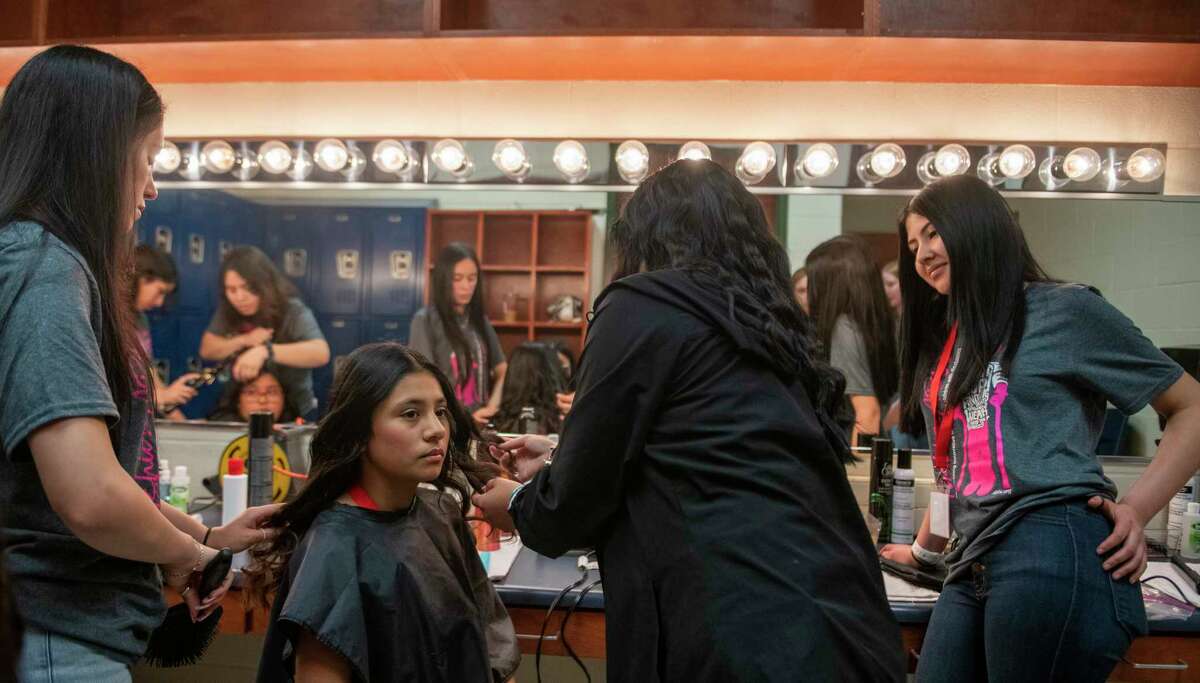 Ariana Gutierrez, 12, middle left, has her hair styled by Holmes students Cazandra Santiago, 17, left, Deayana Ramirez, 16, middle right, as Amberlyn Reyna-Martinez, 17, a design student at Wagner High School looks on backstage at Stevens High School auditorium during Fashion Able. In this fashion show, children with spina bifida and other disabilities will model garments created with fashion design students from six local high schools on Saturday, April 23, 2022. Gutierrez, who has Erb's palsy, and Amberlyn Reyna-Martinez, 17, a design student at Wagner High School, collaborated on designing a crop top and ripped mom jeans that Martinez tailored and altered for Ariana's comfort.