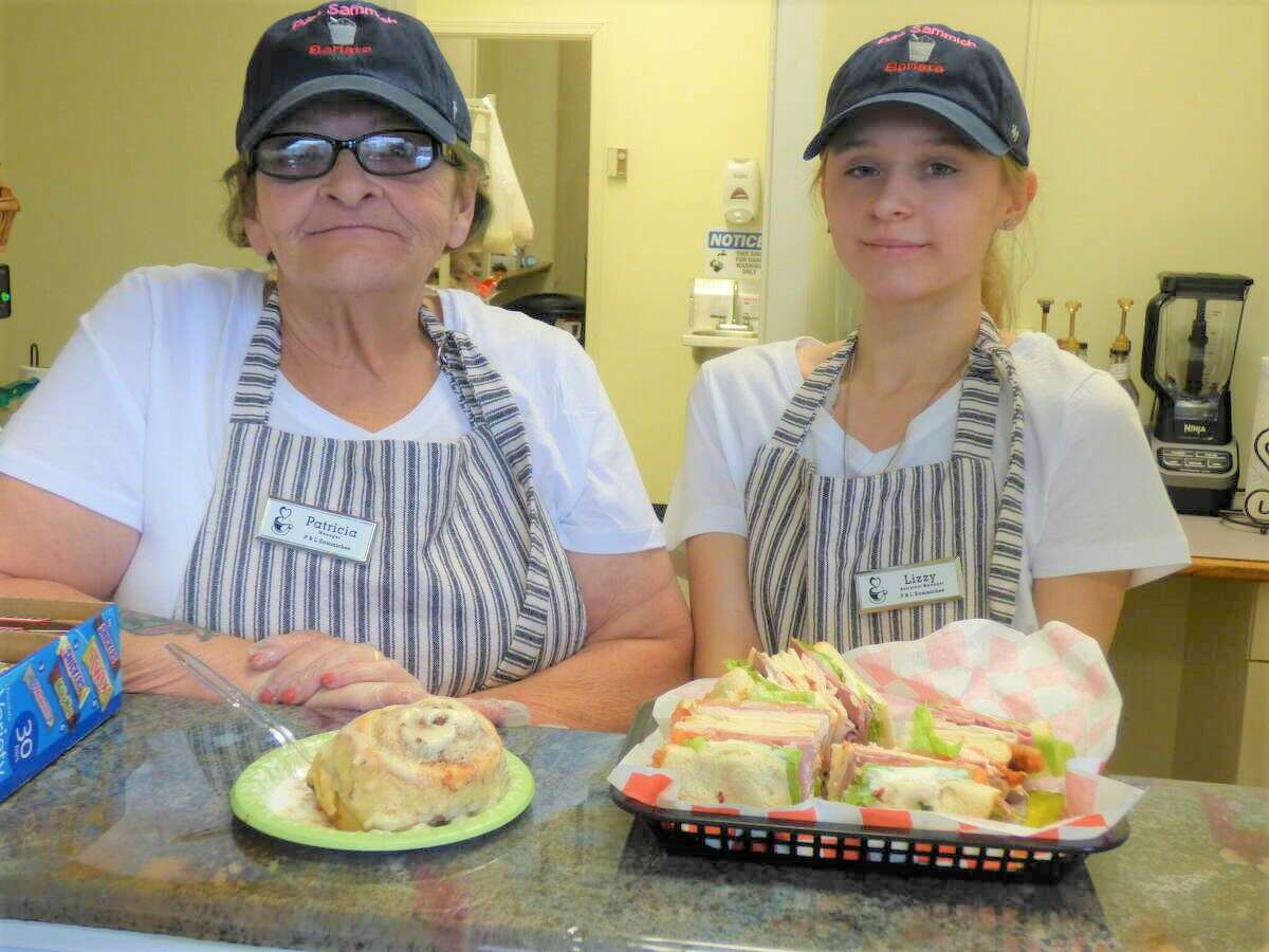 Patricia Schick (left) and her assistant Elizabeth Carroll work the counter at P&L Sammich Barista.  Shick launched a new sandwich shop in downtown Manistee in March.