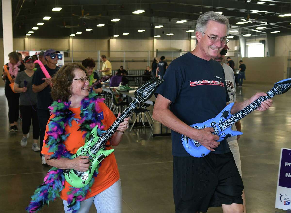 Delin Melancon, left, of Spring and the co-chair for Relay For Life of Northwest Harris County, and her husband Ben, join the “Relay Like a Rockstar” lap with their team during the Relay For Life of Northwest Harris County at the Klein Multipurpose Center in Klein on Saturday, April 23, 2022. The event is a fundraiser for the American Cancer Society to celebrate survivors and remember those who have passed away.