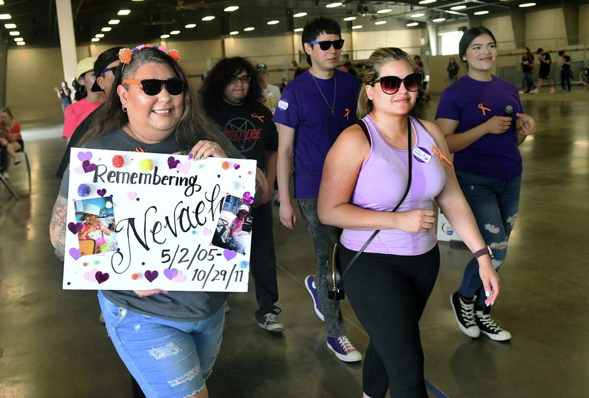 Amy Navarro, from left, of Victoria, holds a sign for her daughter Nevaeh and joined by her cousin Adilia Carmona, of Katy, leads her team during the Relay For Life of Northwest Harris County.