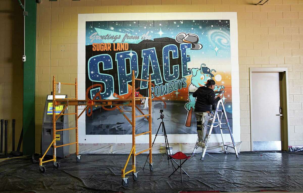 Jesse de Leon puts the finishing touches on a painting for the Space Cowboys at Constellation Field on Saturday, Jan. 29 in Sugar Land.