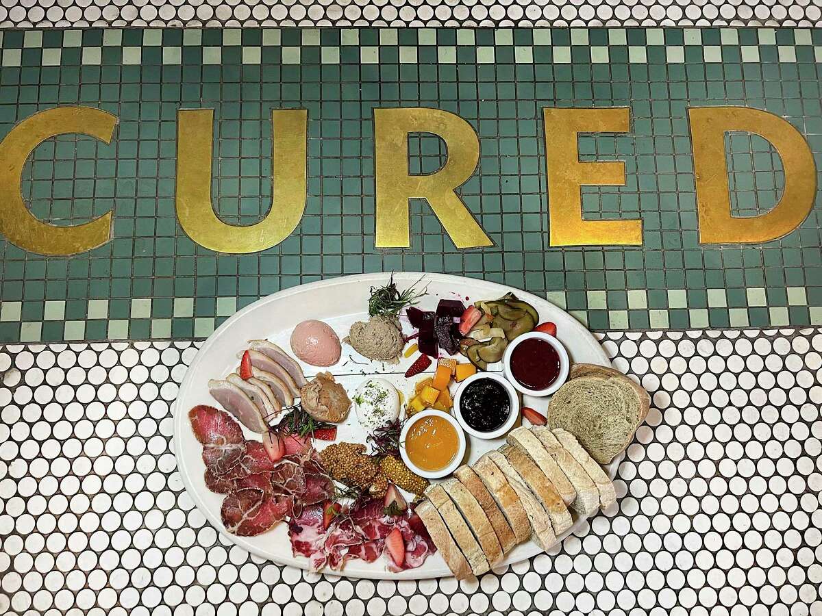 A charcuterie board incorporates house-cured meats, pickles, jams, bread and other condiments at Cured at the Pearl.
