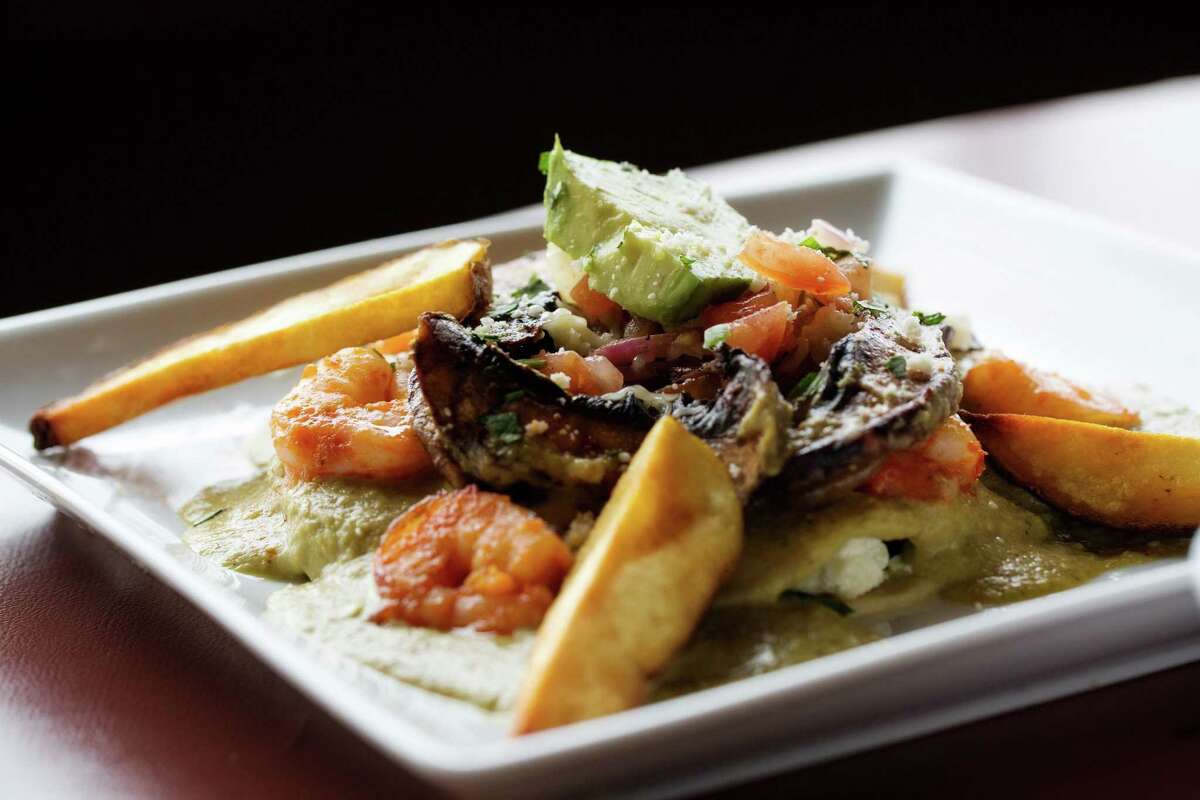 The signature dish at Mestizo restaurant in Baton Rouge, La., is stacked enchiladas with mole verde, spinach, feta cheese, portobello mushrooms, and grilled shrimp served with potato spears.
