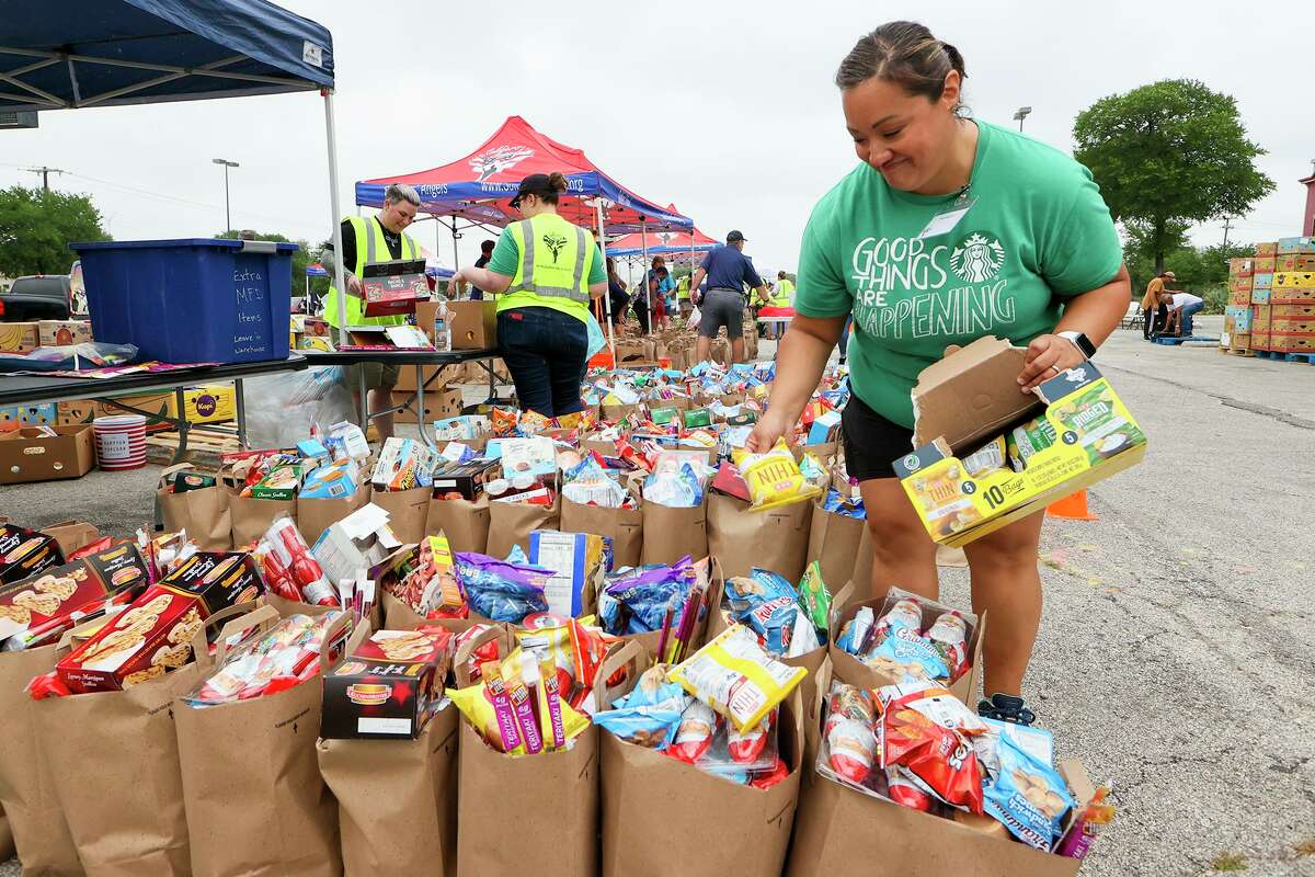 Volunteer Jessica Terry helps fill donation bags with chips, cookies and crackers at the snack tent April 21 at the Soldiers’ Angels food pantry.