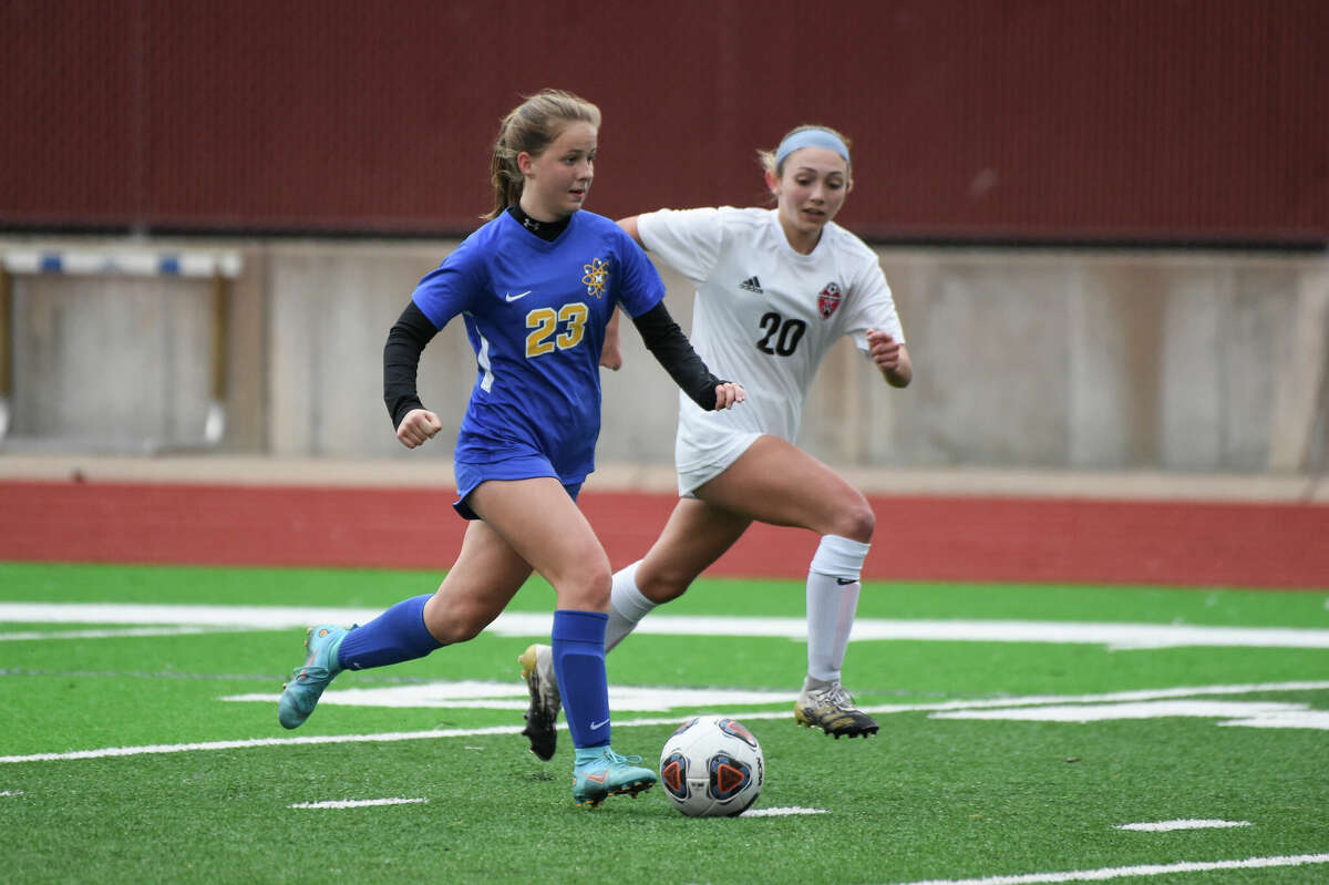 Midland's Elizebeth Striebel dribbles past a defender during the Chemics' game against Grand Blanc Monday, April 25, 2022 at Midland High School.