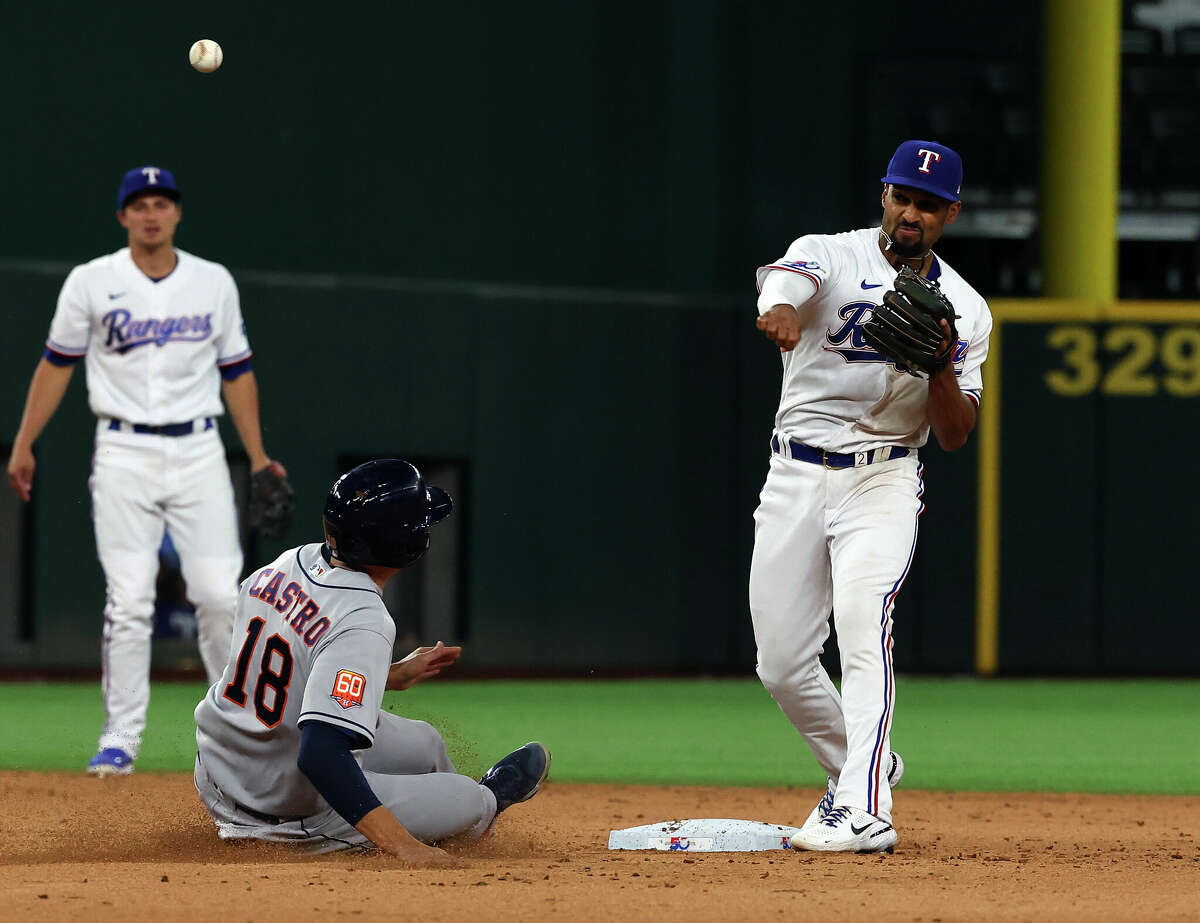 ARLINGTON, TEXAS - APRIL 25: Jason Castro #18 of the Houston Astros is forced out at second base as Marcus Semien #2 of the Texas Rangers makes the throw to first in the fifth inning at Globe Life Field on April 25, 2022 in Arlington, Texas. (Photo by Richard Rodriguez/Getty Images)