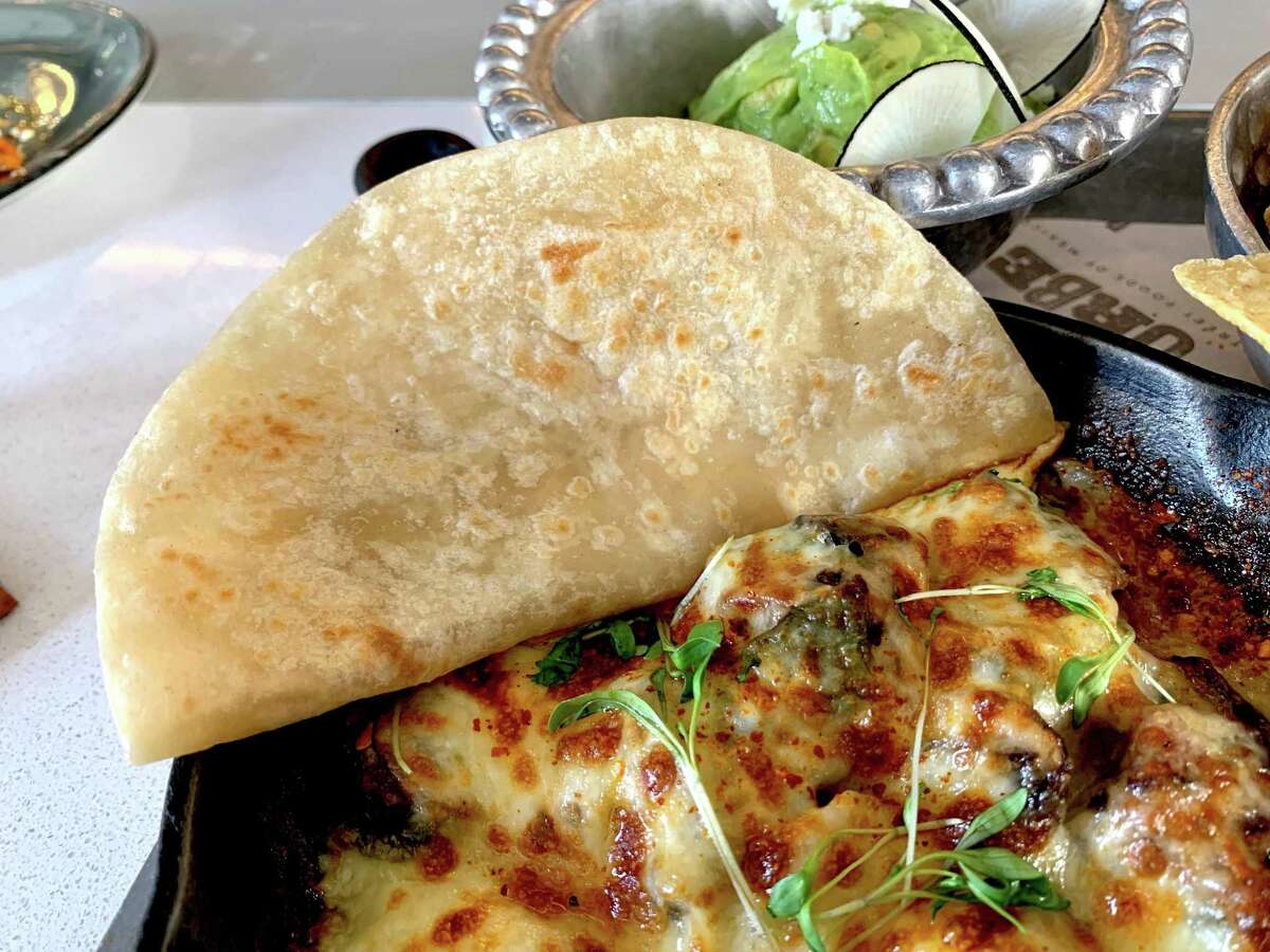 Queso flameado with smoked brisket and house-made flour tortillas at Urbe, Hugo Ortega’s casual Mexican street food spot in Uptown Park.