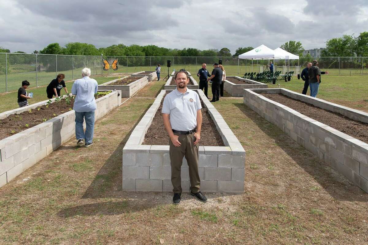 Pasadena Parks Director Jed Aplaca stands in front of a raised bed at the Vince Bayou Community Garden.