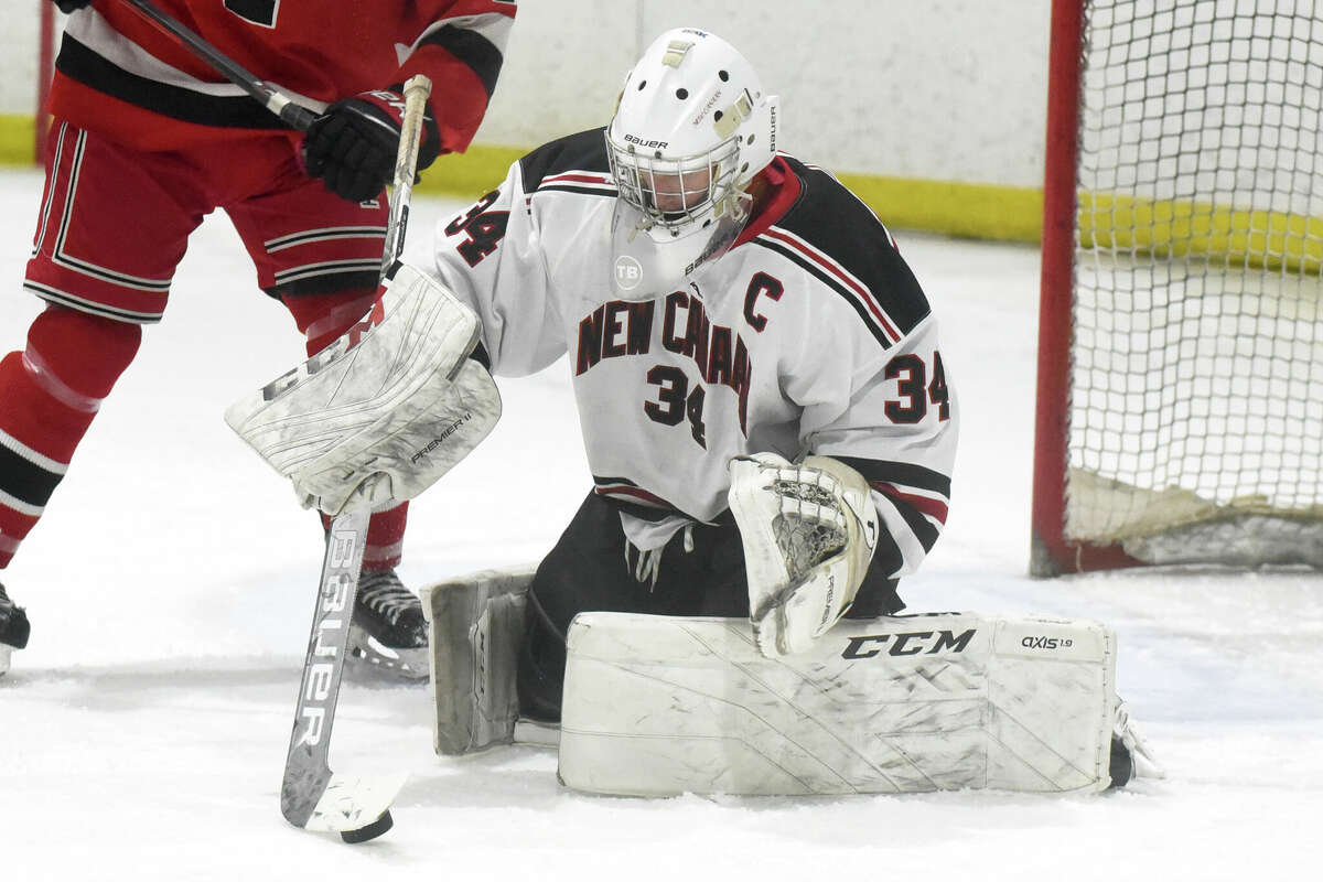 New Canaan goalie Beau Johnson gathers in the puck after making a save against Fairfield in a boys ice hockey game at the Darien Ice House on Monday, Feb. 14, 2022.