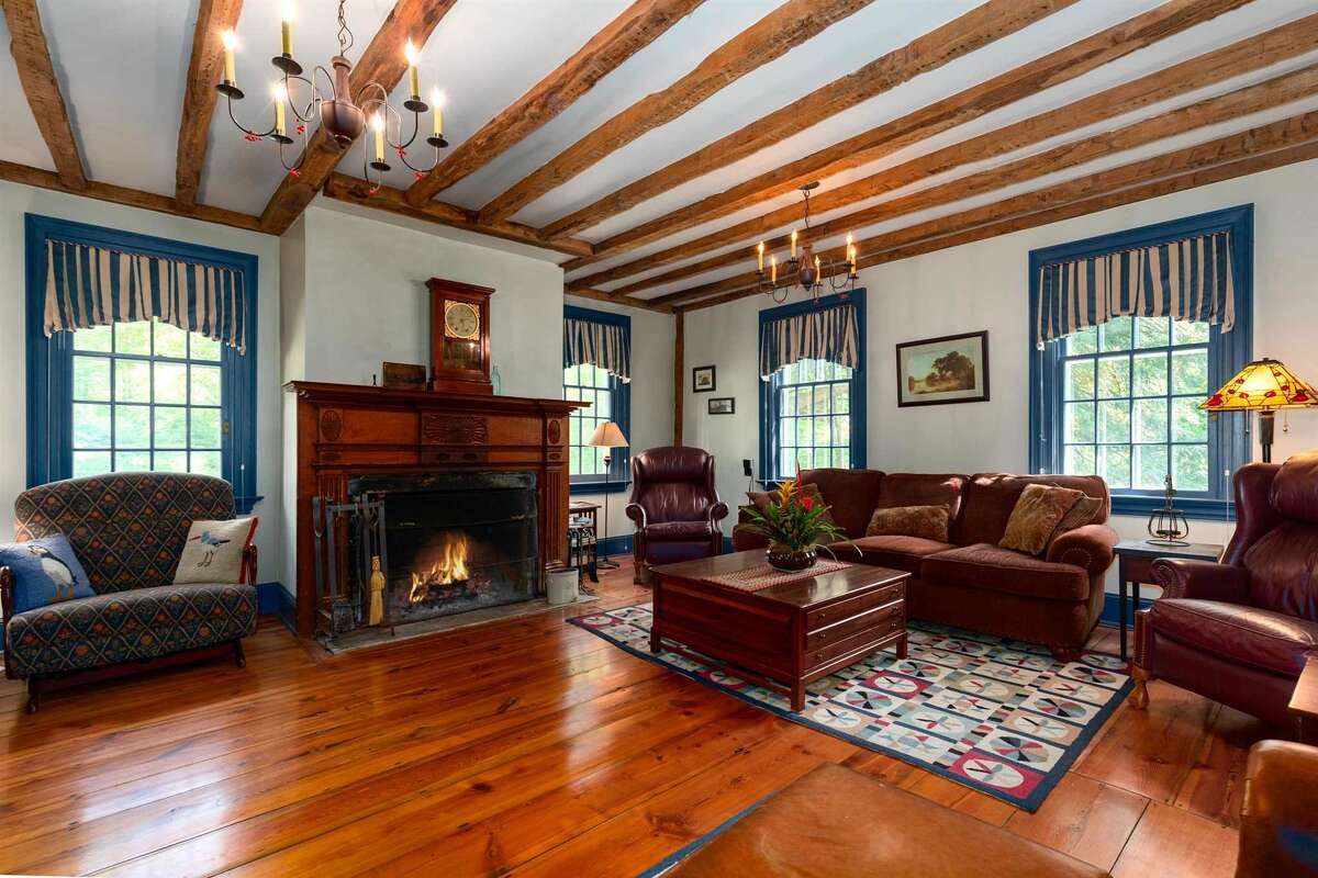 A wood-burning fireplace and wooden-beamed ceiling adorn the living room.