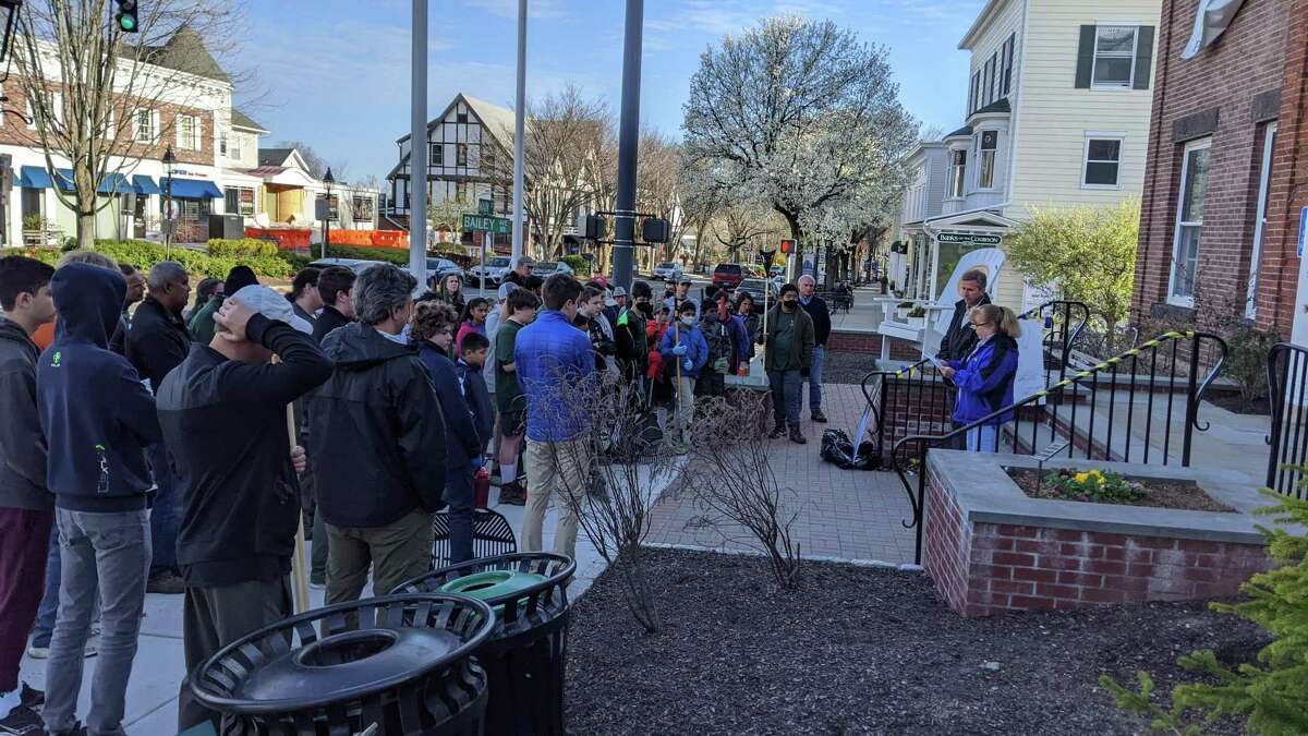 Scouts cleaned up Main Street on Saturday, April 23 in honor of Ryan Adams, a Ridgefield Eagle Scout who died at 18 in a plane crash. His parents, Mary Lou and John Adams, are pictured speaking to the crowd.