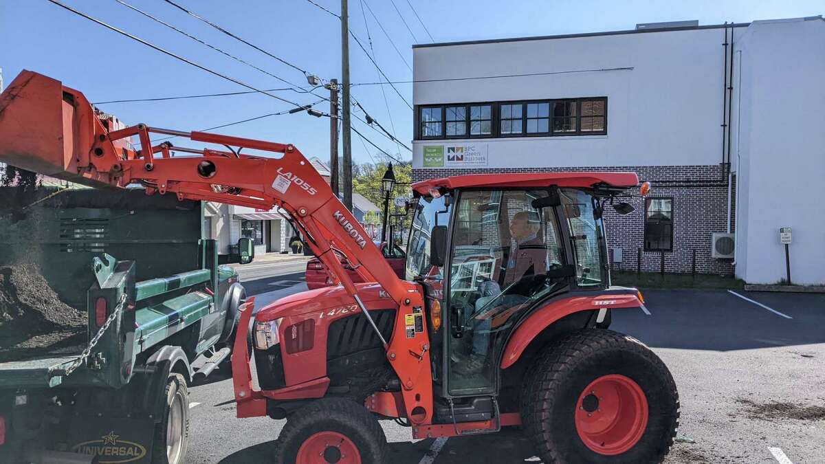 Scouts cleaned up Main Street on Saturday, April 23 in honor of Ryan Adams, a Ridgefield Eagle Scout who died at 18 in a plane crash. First Selectman Rudy Marconi assisted by loading the mulch for the scouts to spread from the truck.