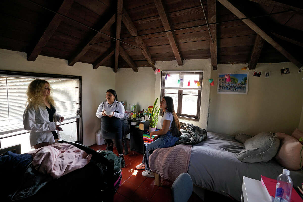 Students Sofia Howard-Jimenez (from left), Jennifer Lopez and Aisha Wallace-Palomares talk in a loft bedroom of the apartment they share.