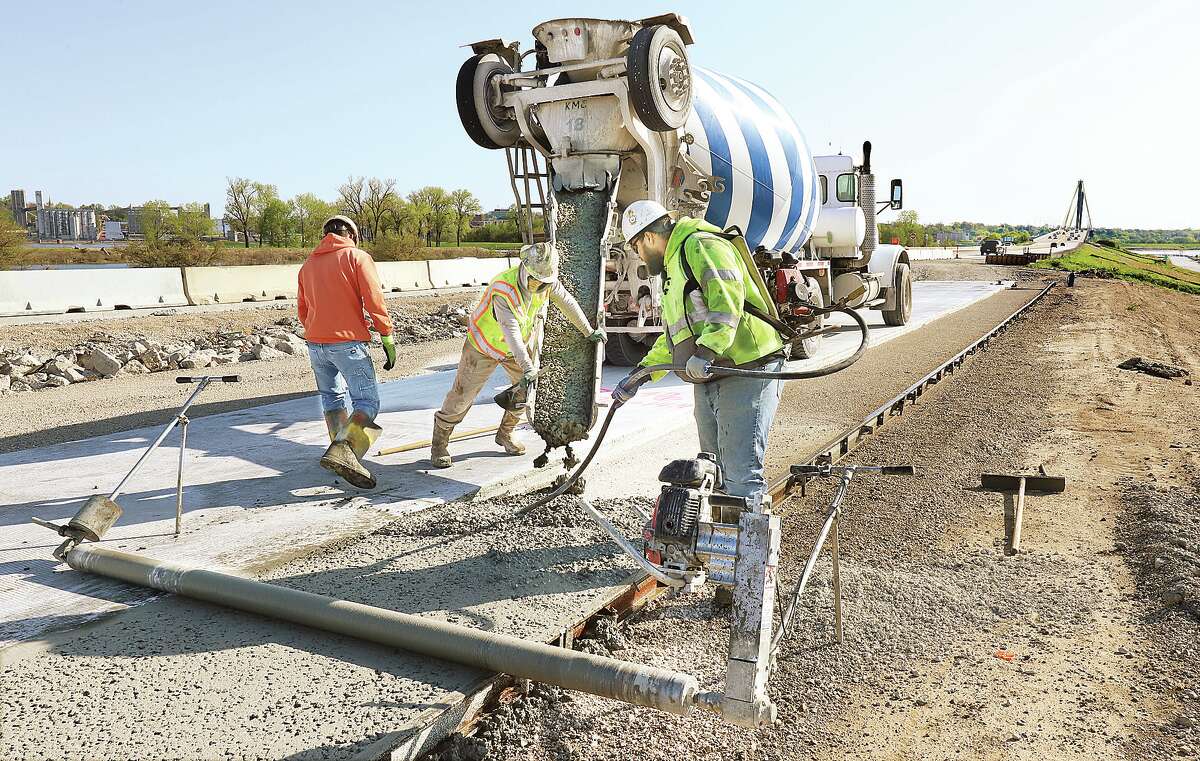 John Badman|The Telegraph Workers were pouring concrete Tuesday for the soon to be relocated southbound lanes of U.S. 67 in West Alton, Missouri. The work has progressed to the section closest to the Clark Bridge, right, which will include a new tie in to the existing lanes of traffic. The lower southbound lanes, which are prone to flooding, are being relocated along side the higher northbound lanes. The section being done is about the first mile after crossing the Clark Bridge. This will not prevent all flooding from covering the roadway but will eliminate the flooding risk in smaller floods. Cost of the relocation is about $7 million; work is expected to be completed by the end of the year.