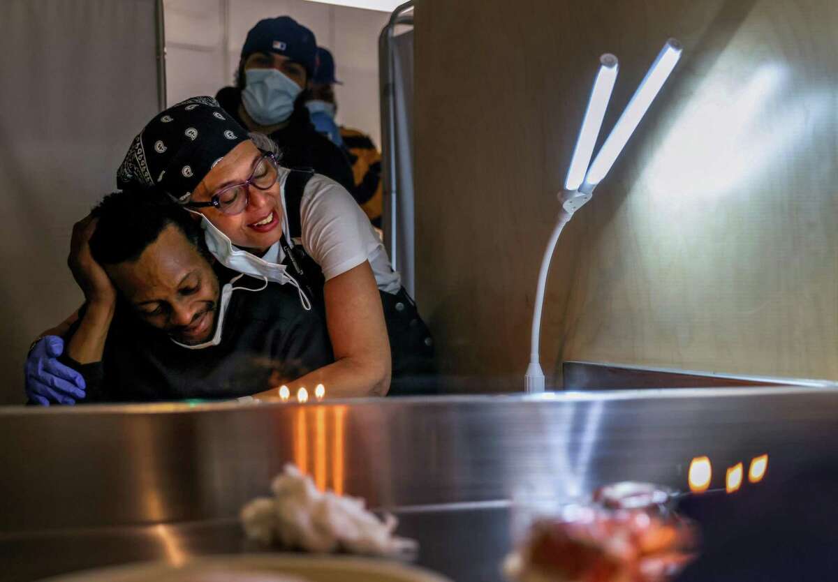 Harm reduction specialist Alsane Mezon (right) embraces client Yedidiah Ysrael (left) with a cake on his birthday at OnPoint NYC, a supervised drug injection site in Harlem on Thursday, March 24, 2022 in New York, New York.