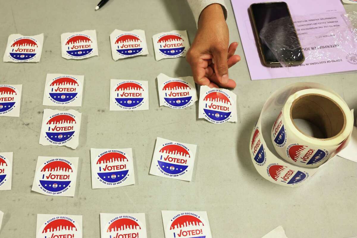 A poll worker lays out "I Voted" stickers on a table on June 22, 2021, primary Election Day, at a school in the Flatbush neighborhood of Brooklyn. (Photo by Michael M. Santiago/Getty Images)