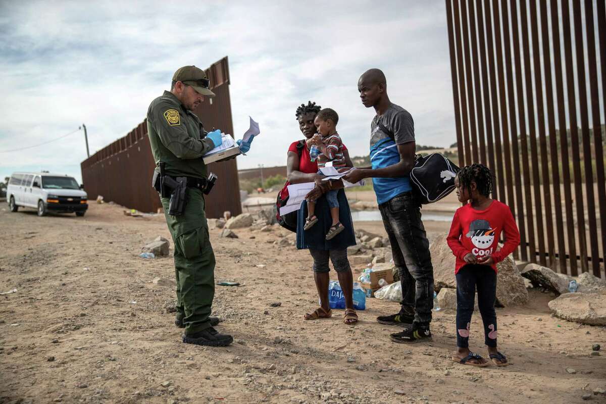 An immigrant family from Haiti is taken into custody by a U.S. Border Patrol agent at the U.S.-Mexico border on December 07, 2021 in Yuma, Arizona.