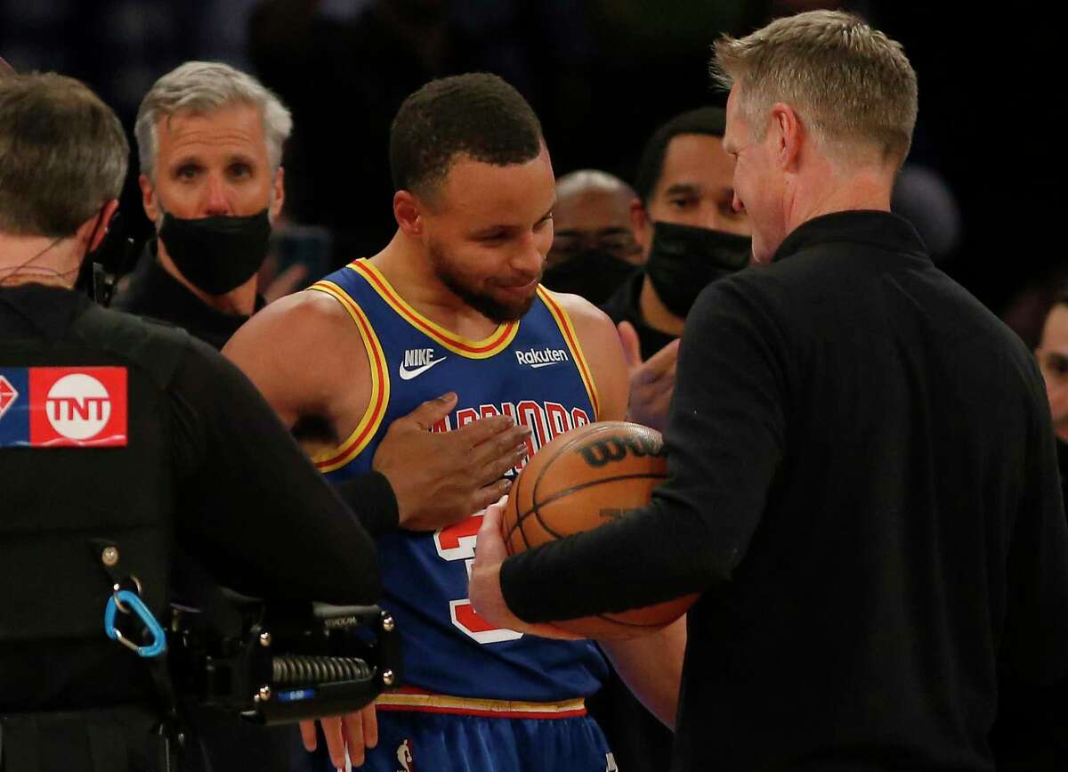 Stephen Curry #30 of the Golden State Warriors hugs head coach Steve Kerr after shooting a three point basket to become the NBA's all-time leader during the first quarter against the New York Knicks at Madison Square Garden on December 14, 2021 in New York City. 