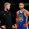 Golden State Warriors head coach Steve Kerr talks with Golden State Warriors guard Stephen Curry (30) during the first half of an NBA basketball game against the Los Angeles Lakers in Los Angeles, Tuesday, Oct. 19, 2021. (AP Photo/Ringo H.W. Chiu)