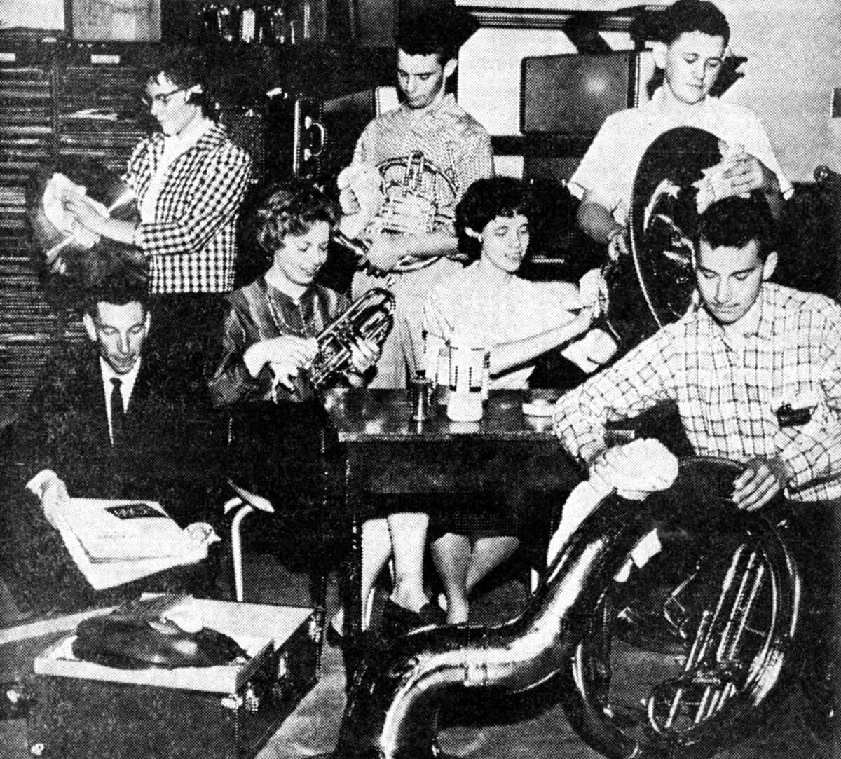 Some of the 75 musicians in the Manistee High School band go over their horns with polishing cloths as band Director Paul Cramer sorts the sheet music the band is set to play in today's performance. (From left, front row) Cramer, Lynette Raatz, Susan Rosenow and Randy Steffens. (From left, standing) Colleen Haynes, Dave Chambers and John Zawacki. The photo was published in the News Advocate on April 28, 1962.
