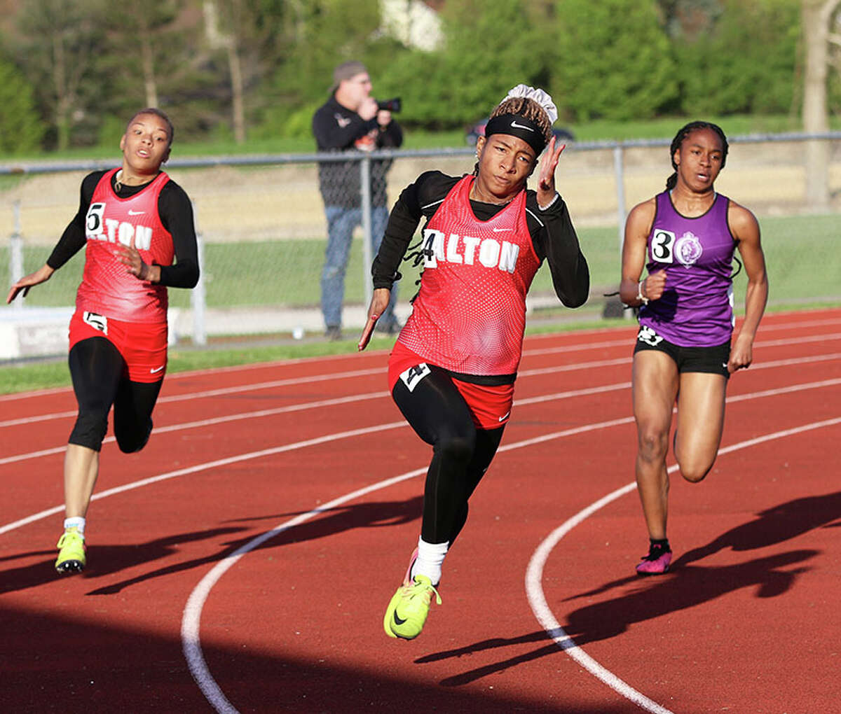 Alton's Renee Raglin (middle) leads teammate Khaliyah Goree (left) and Collinsville's Deairra Spears through the turn in the 200 meters on Tuesday at the Madison County large-schools girls track meet in Edwardsville. 