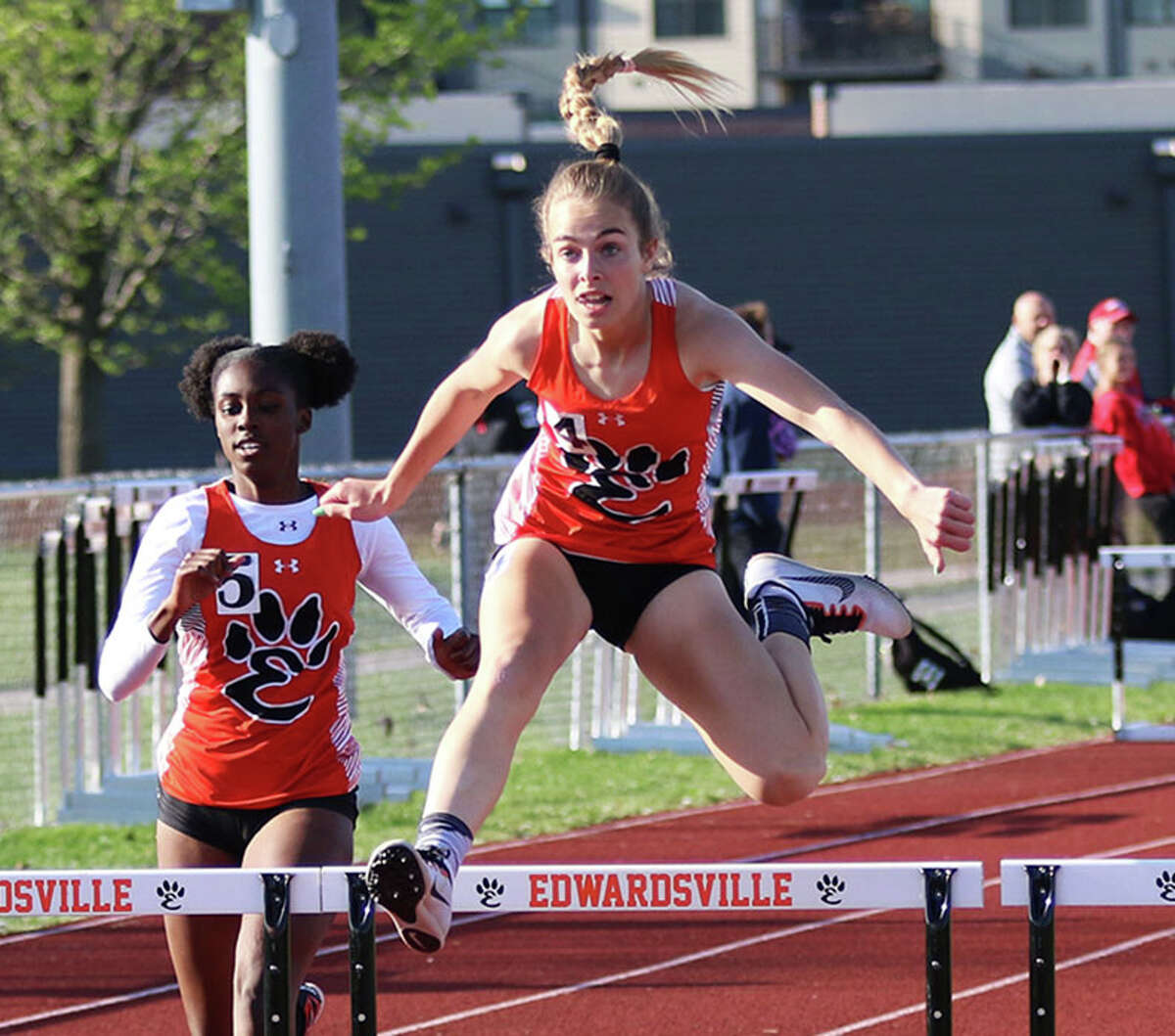Edwardsville's Blakely Hockett (right) clears a hurdle ahead of teammate Sydnee Campbell in the 300-meter hurdles on Tuesday at the Madison County large-schools girls track meet in Edwardsville. Hockett won the race, with Campbell in second.