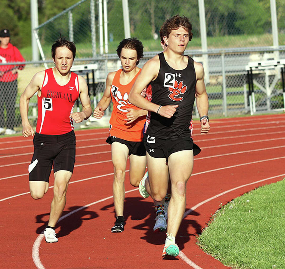 Edwardsville's Ryan Luitjohan (right) leads Highland's Dallas Mancinas (left) and Edwardsville's Hugh Davis through the turn in the 1,600 meters on Tuesday at the Madison County large-schools boys track meet at Edwardsville.