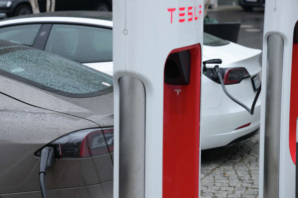 Tesla electric cars charge at a Tesla charging station.