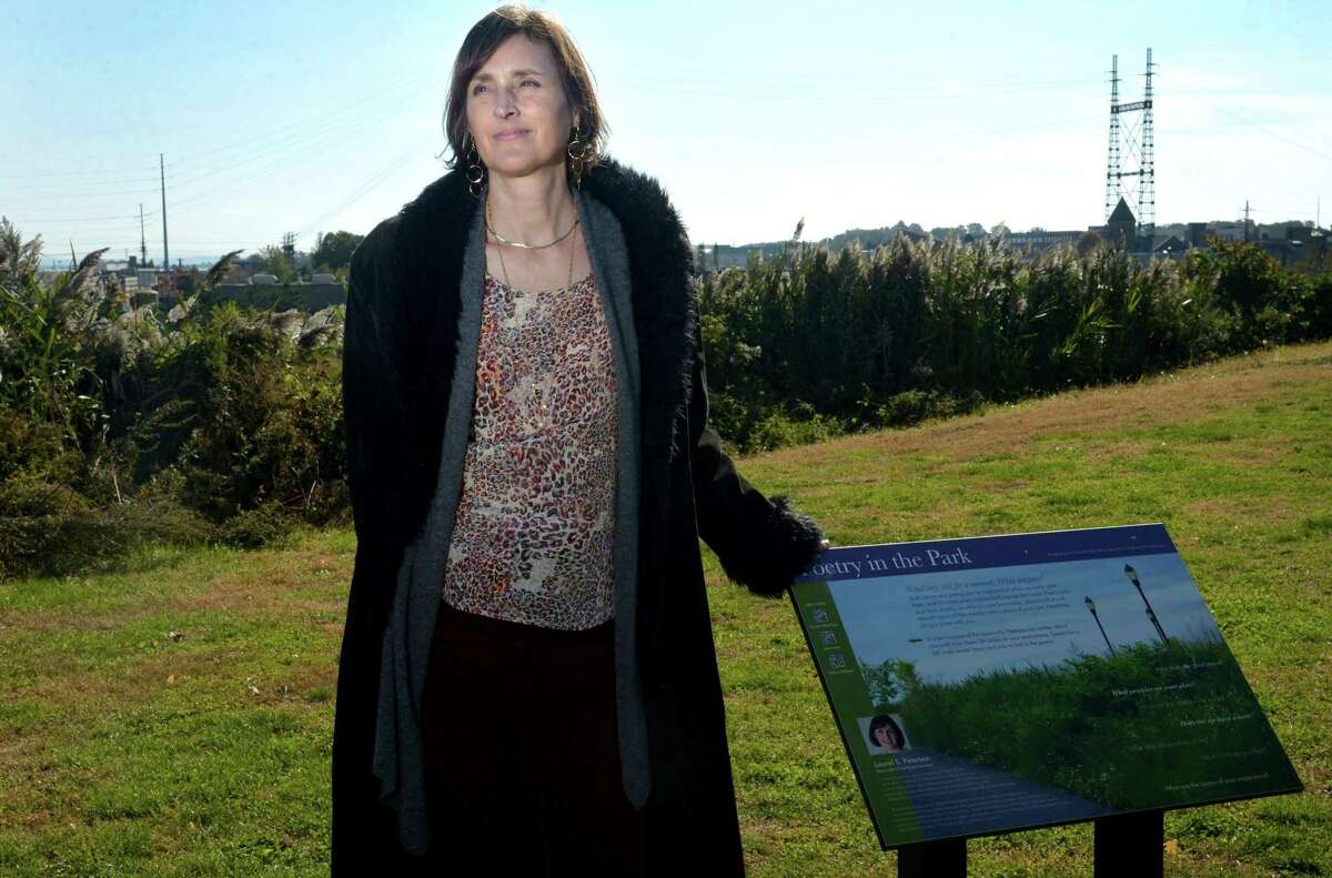 Norwalk Poet Laureate Laurel Peterson, whose three year term as Norwalk’s first poet laureate came to an end, next to the sign that was installed during her tenure at Oyster Shell Park Wednesday, October 31, 2018, in Norwalk, Conn.