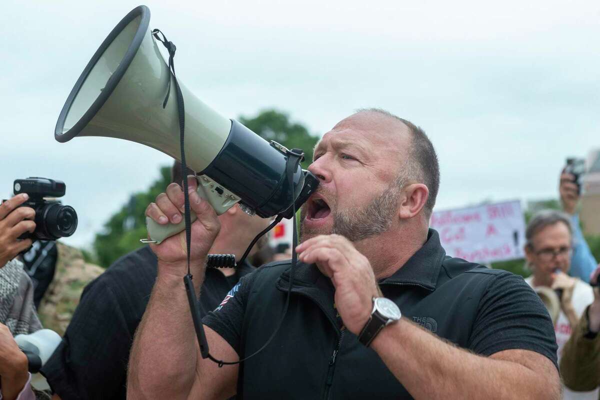 Alex Jones speaks to the protesters gathering at the Texas Capitol in Austin looking to end to the coronavirus shutdowns, Saturday, April 19, 2020.
