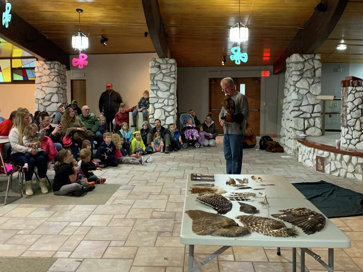Chris Johnson, Skegemog Raptor Center assistant director, talks with a large crowd on Thursday at the Wagoner Community Center about birds of prey. The event was part of a series hosted by the Manistee County Library.