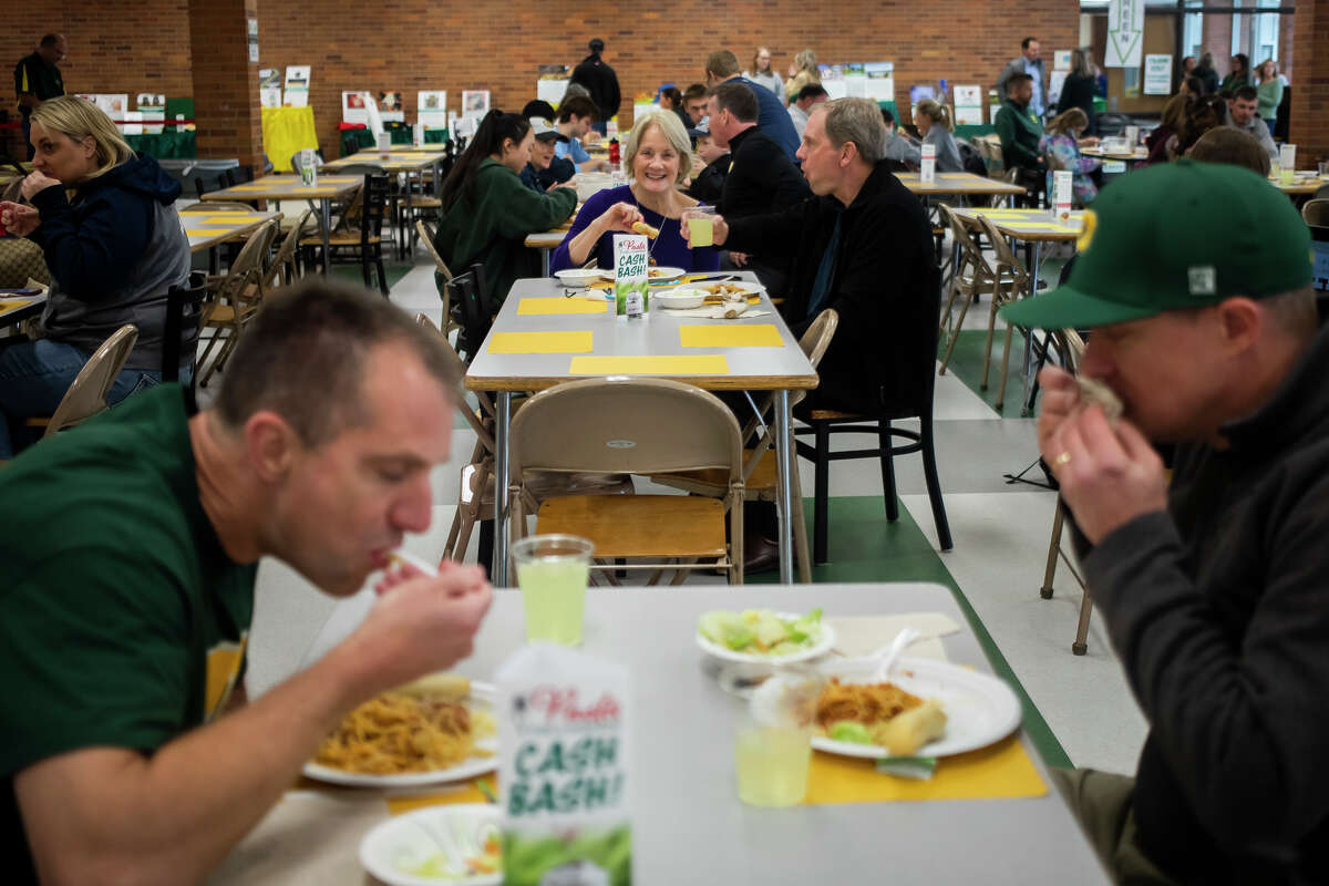 Gli allenatori Dow Excessive servono cene a base di spaghetti durante la raccolta fondi Pasta with a Objective 3 Agli ospiti vengono serviti spaghetti e grissini dagli allenatori Dow durante Pasta with a Purpose, un evento di raccolta fondi per il Dow High Sports Booster Club martedì 26 aprile 2022 presso la scuola di Midland.