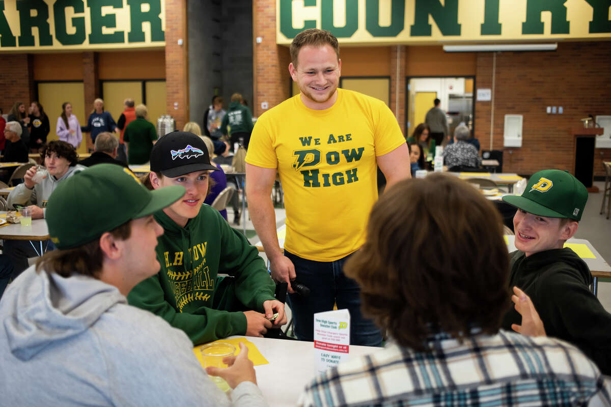 Alex Karapas, center, chats with Dow student athletes during Pasta with a Purpose, a fundraising event for the Dow High Sports Booster Club Tuesday, April 26, 2022 at the school in Midland.