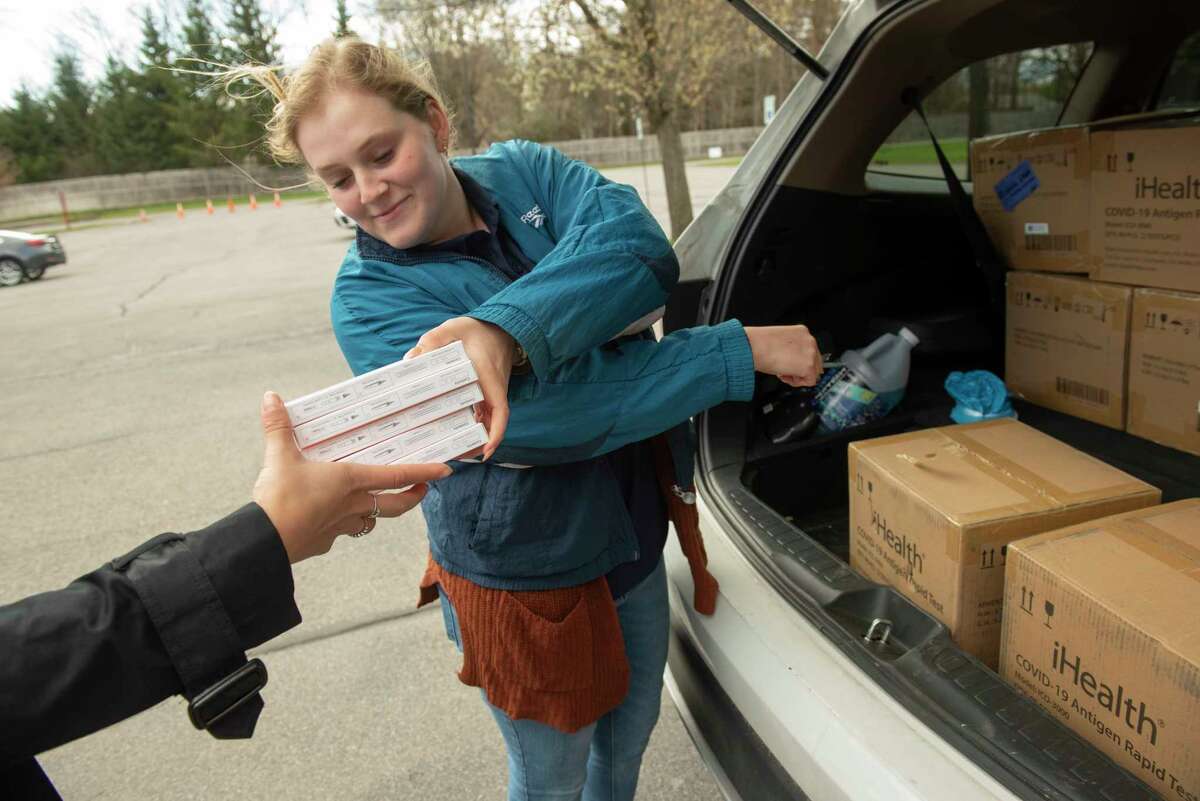 Volunteer Abby Burke of Saratoga Springs hands COVID tests from a car to volunteer Amanda Braynack of Queensbury, left, to hand out during a drive-thru event hosted by Assemblywoman Mary Beth Walsh at Clifton Common on Wednesday, April 27, 2022 in Clifton Park, N.Y. Distribution was limited to 5 test kits per car and are only available to residents and businesses of the 112th Assembly District.