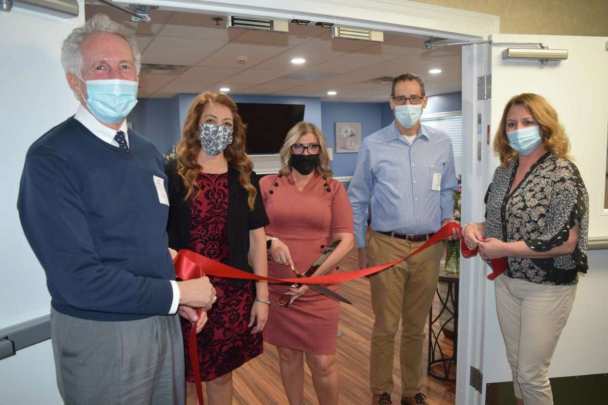Amy York (center), executive director for The Pointe at Morris, cuts the ribbon on the New Day Neighborhood memory care wing at The Pointe at Jacksonville. York came up with the design of the wing.