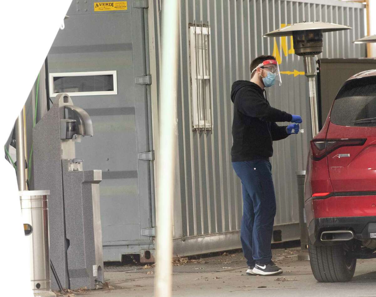A health care worker takes a sample from a driver at a drive-thru COVID testing tent set up at Saratoga Hospital Wednesday, April 27, 2022 in Saratoga Springs, N.Y.