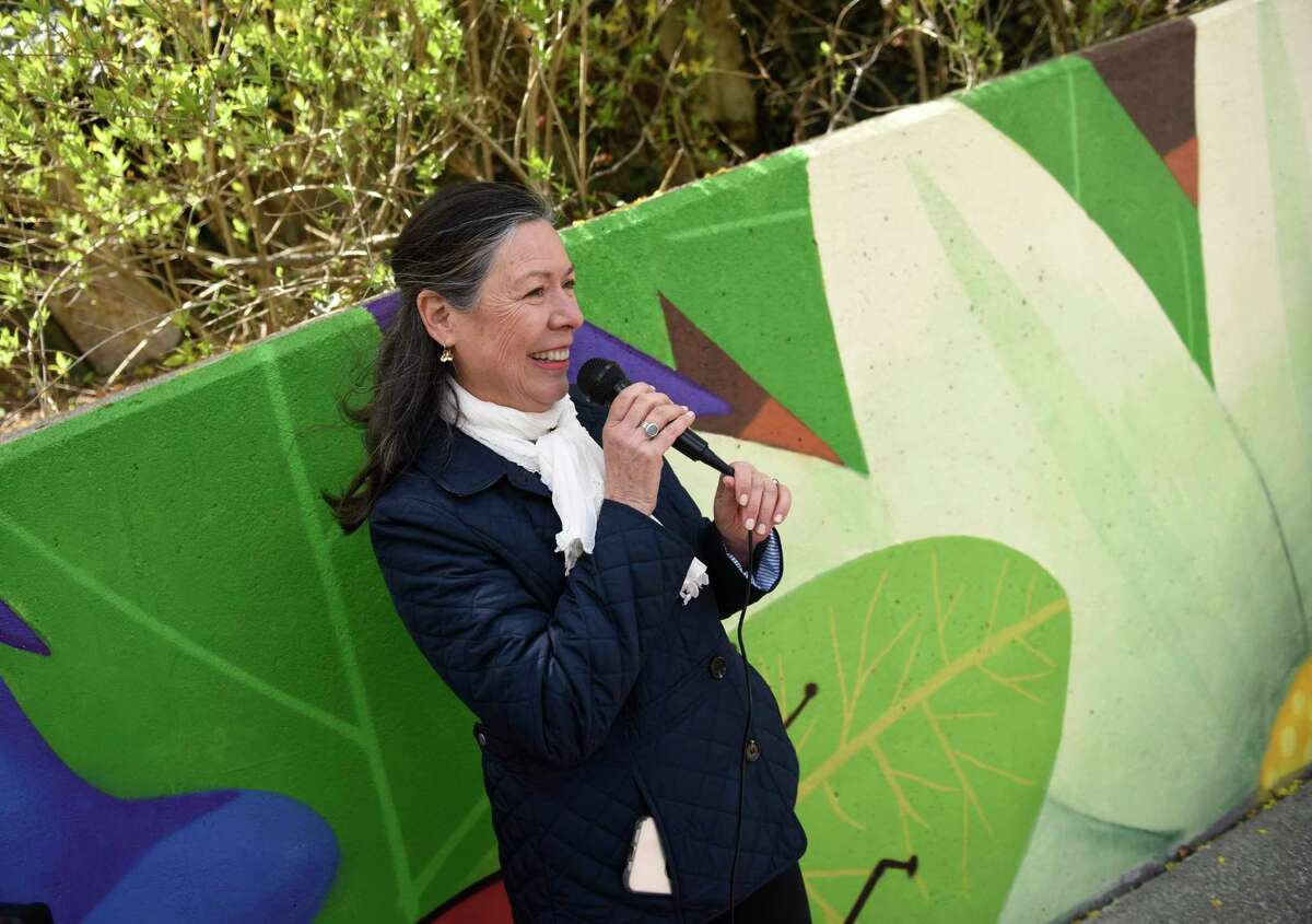 Mural and pollinator garden leader Myra Klockenbrink speaks at the unveiling of the pollinator pathway garden and mural at the bus stop across from Cardinal Stadium on East Putnam Avenue in Greenwich, Conn. Wednesday, April 27, 2022. The colorful mural depicting a garden scene was recently completed by Nelson "Cekis" Rivas and his assistant Yedi. Beside the mural and bus stop, invasive species were cleared to make room for native shrubs, herbaceous plants, bulbs and vines.