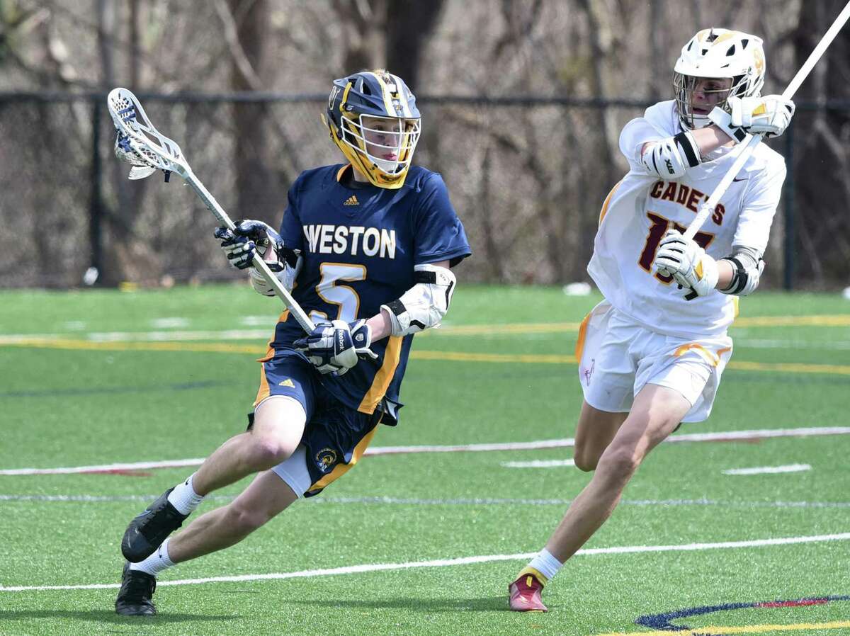 Weston’s Henry Katz (5) comes around the back of the net with St. Joseph’s Jason Pagano (17) defending on April 9.