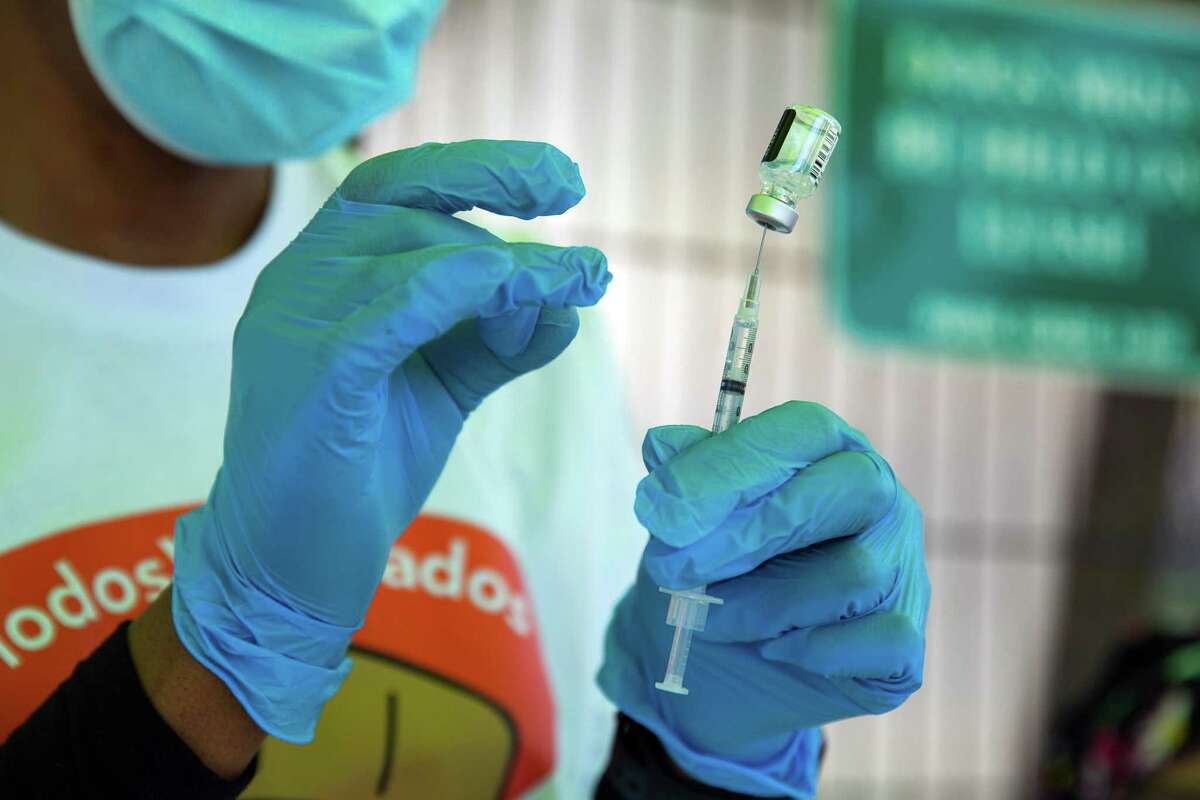 A registered nurse prepares a COVID vaccine during a community health fair in San Francisco last April.