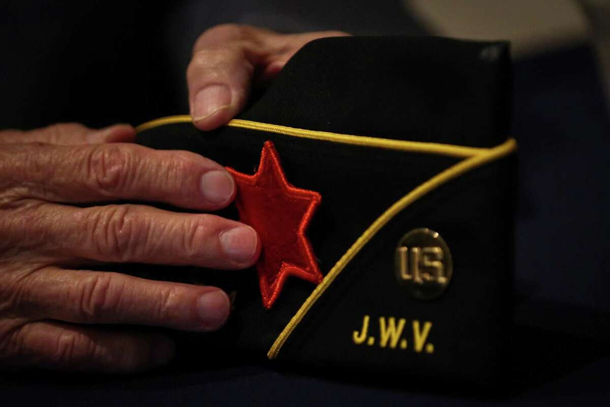 Bill Orlin talks about his time in the military, as he touches a patch from an infantry unit he trained with, after a Yom HaShoah ceremony for Holocaust Remembrance Day on Sunday April 24, 2022, at Congregation Beth Israel in Houston. Orlin is a Holocaust survivor and American veteran who served as an occupier in Germany after World War II. He said he wanted to make sure people knew the Holocaust happened.
