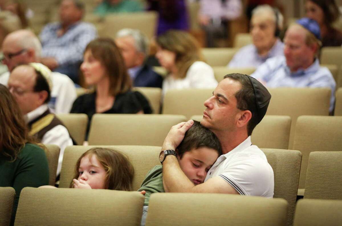 Benjamin Kass holds his son Zev, 5, during a Yom HaShoah ceremony for Holocaust Remembrance Day Sunday, April 24, 2022, at Congregation Beth Israel in Houston. Kass said his grandparents survived, but the rest of his family was killed.