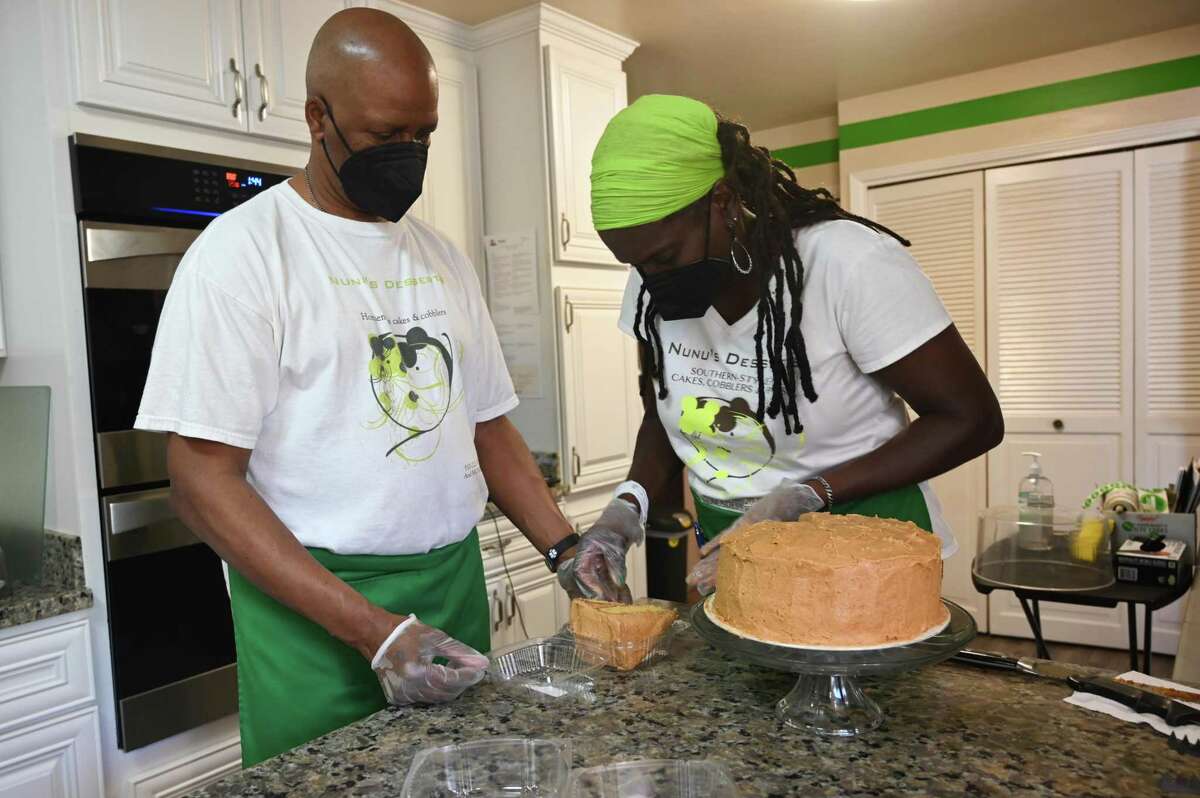Lee Nora Glover-Holloway, a.k.a. Mrs. NuNu, and her husband, Derek Holloway, package cake slices from their Vallejo home for their home food bakery Nunu’s Desserts with Soul.