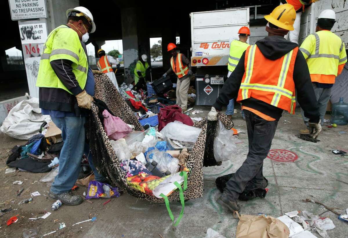 A Caltrans crew removes debris near the eastbound on-ramp after officers cleared out a homeless encampment on Gilman Street below Interstate 80 in Berkeley in 2016.
