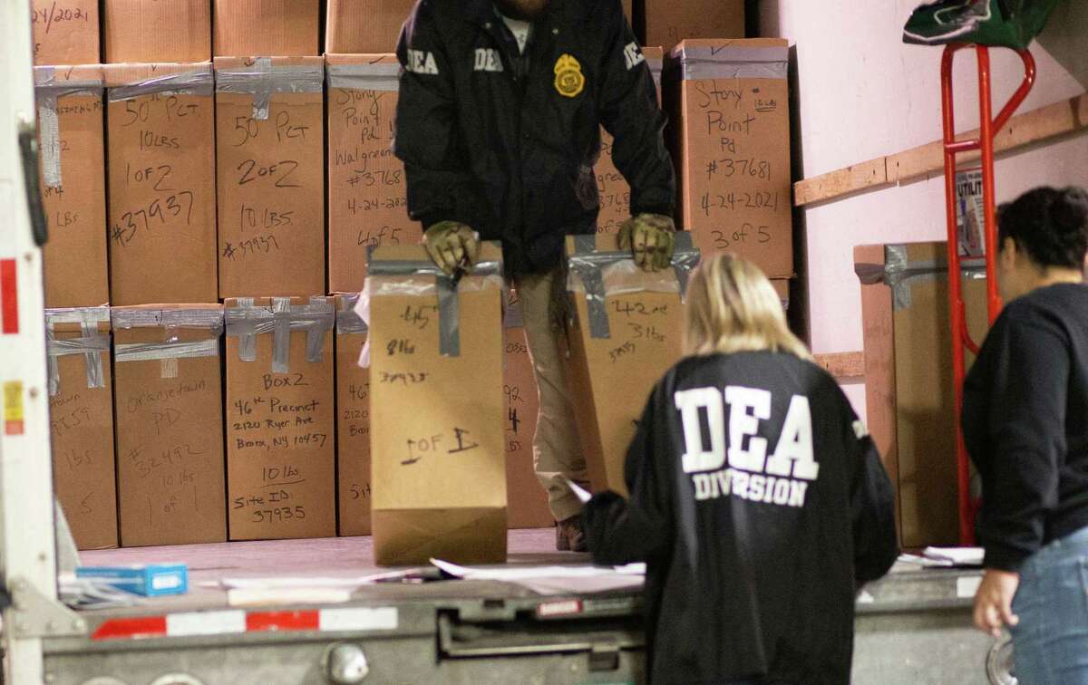 Agents from the Drug Enforcement Administration pick up packages of collected medications during 2021 Take Back Day.