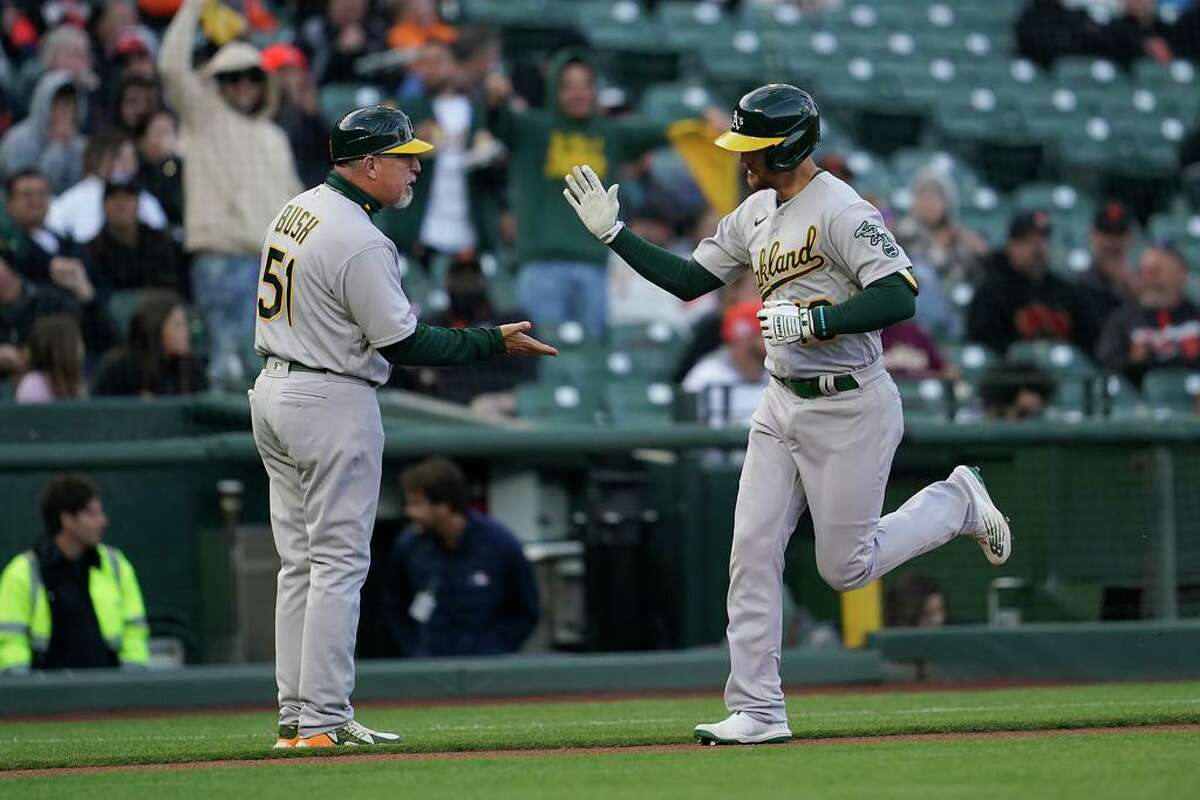 Oakland Athletics' Chad Pinder, right, is congratulated by third base coach Darren Bush after hitting a home run against the San Francisco Giants during the first inning of a baseball game in San Francisco, Wednesday, April 27, 2022. (AP Photo/Jeff Chiu)